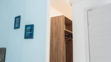 Ein Zimmer mit einem Holzschrank, einer weißen Tür und einer Wandklimaanlage.