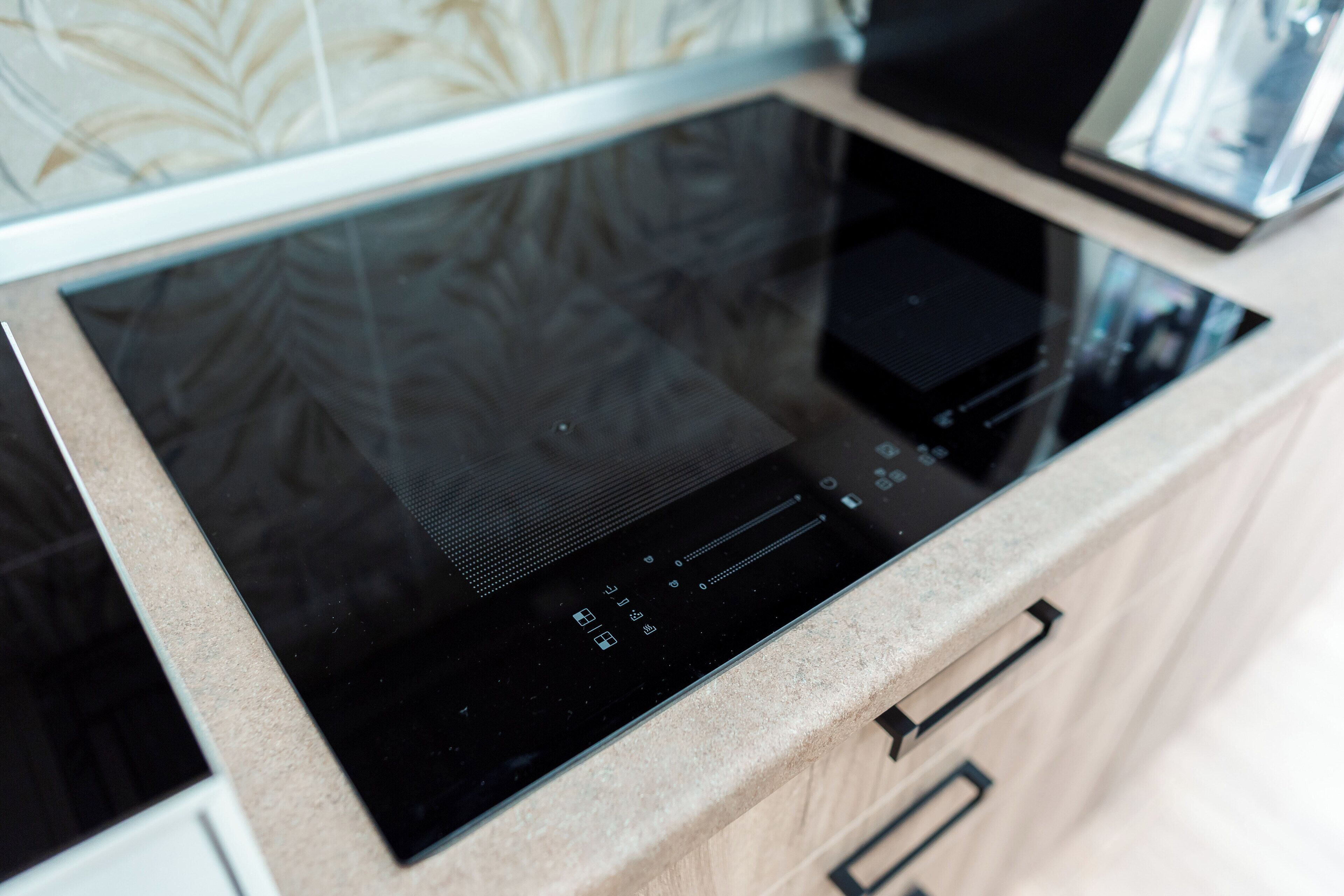 A modern kitchen with a built-in induction cooktop and a microwave.