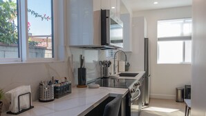 A modern kitchen with a large window, stainless steel appliances, and a clean, minimalist design.
