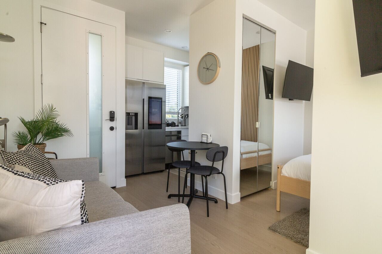 Un appartement moderne comprenant un coin cuisine, un espace repas, un salon avec un canapé et un lit.