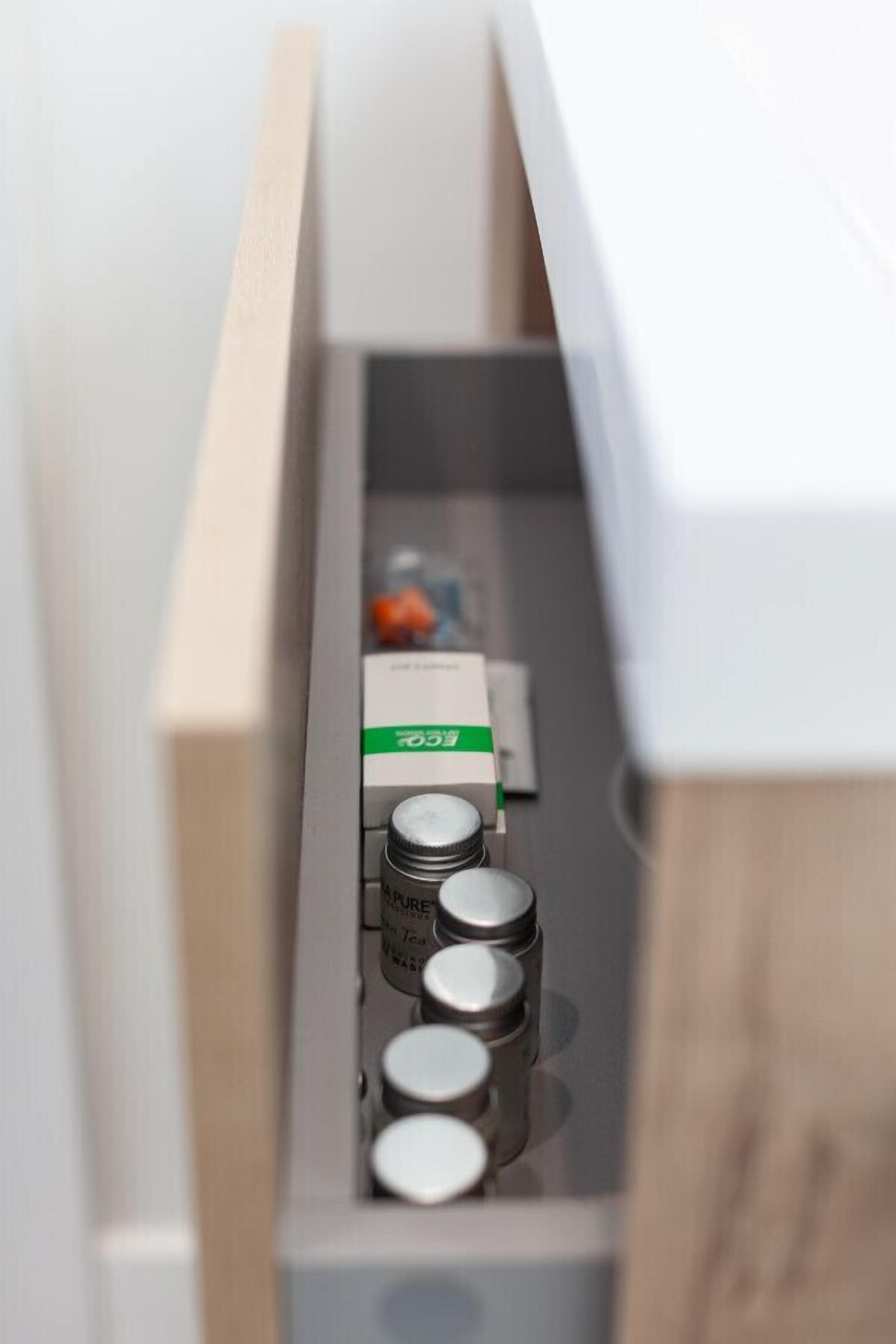 A drawer with a white box labeled 'Pure' and several cylindrical containers.