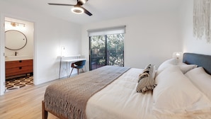 A bedroom with a bed, a desk, a chair, a ceiling fan, and a view of the outdoors. - Surf Shack at Lake Nacimiento with Private Slip! (Bradley)