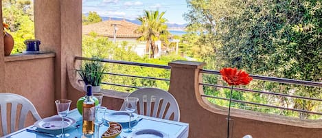 A table set for dining with a view of the countryside.