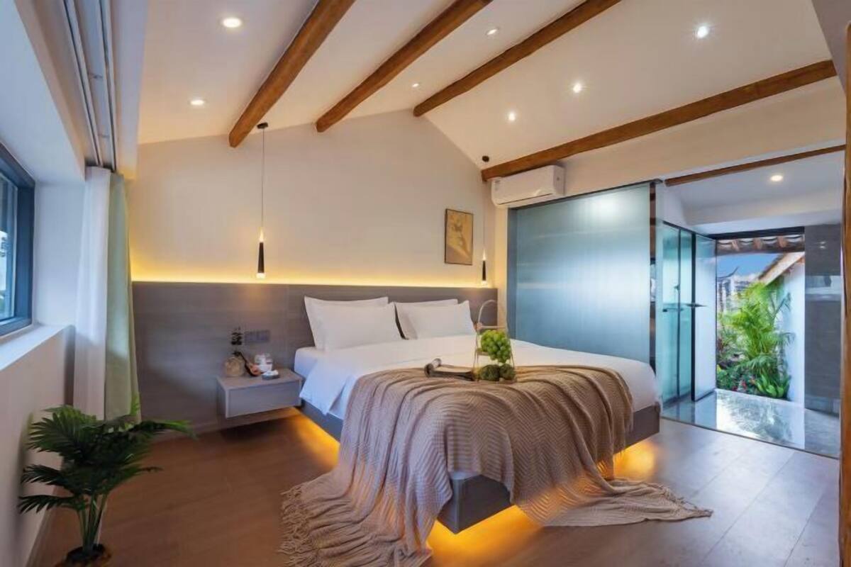 Une chambre moderne avec un lit, une table de chevet et une vue sur un balcon.