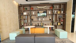 Un soggiorno moderno con televisore, librerie e zone relax.