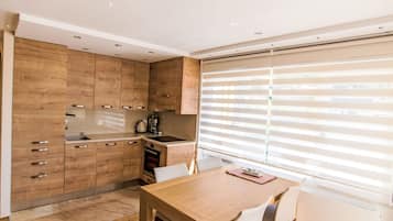 Een koelkast, een oven, een vaatwasser, kookgerei, borden en bestek