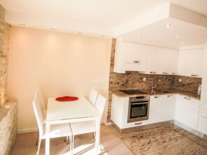 Enjoy meals in this well-equipped kitchen with oven, sink, and dining area.