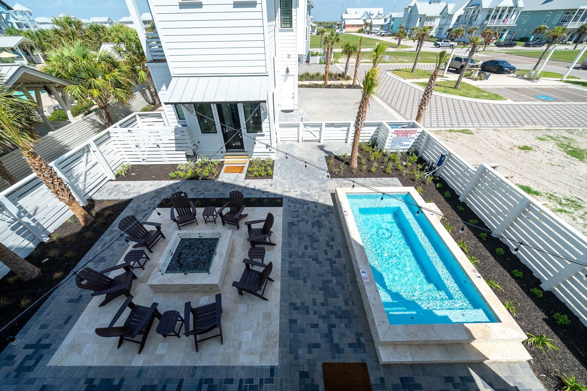 A rooftop pool area with lounge chairs and a fire pit.
