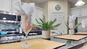 A kitchen with a stainless steel stove, a microwave, and a clock on the wall.