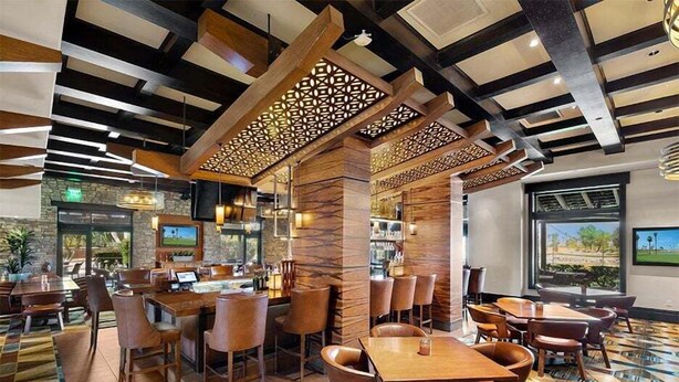A restaurant with a modern interior, featuring wooden beams and a patterned floor.