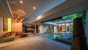 A modern living room with a pool, a dining area, and a kitchen. - Luxury 4-Bedroom Holiday Rental Near Berawa Beach, Bali Villa 2094 (Bali)