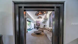 A modern interior with a central seating area, a dining table, and a view of an outdoor pool. - Luxury 4-Bedroom Holiday Rental Near Berawa Beach, Bali Villa 2094 (Bali)