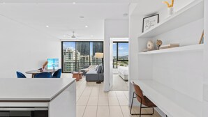 A modern apartment with a kitchen, dining area, and living space, featuring a city view and minimalist decor.