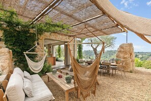 Un espace extérieur accueillant avec un hamac, une table en bois et un canapé.