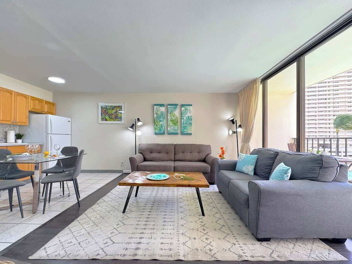 En moderne stue med sofa, spisebord og et køkkenafsnit.