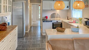 A modern kitchen with a central island, stainless steel appliances, and pendant lighting.