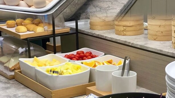 A buffet with various food items including eggs, corn, peanuts, and fruits. - JUN YUE Abuja hotel (Abuja)