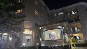 A multi-story hotel with a large illuminated sign, a Christmas tree, and a well-lit entrance. - JUN YUE Abuja hotel (Abuja)