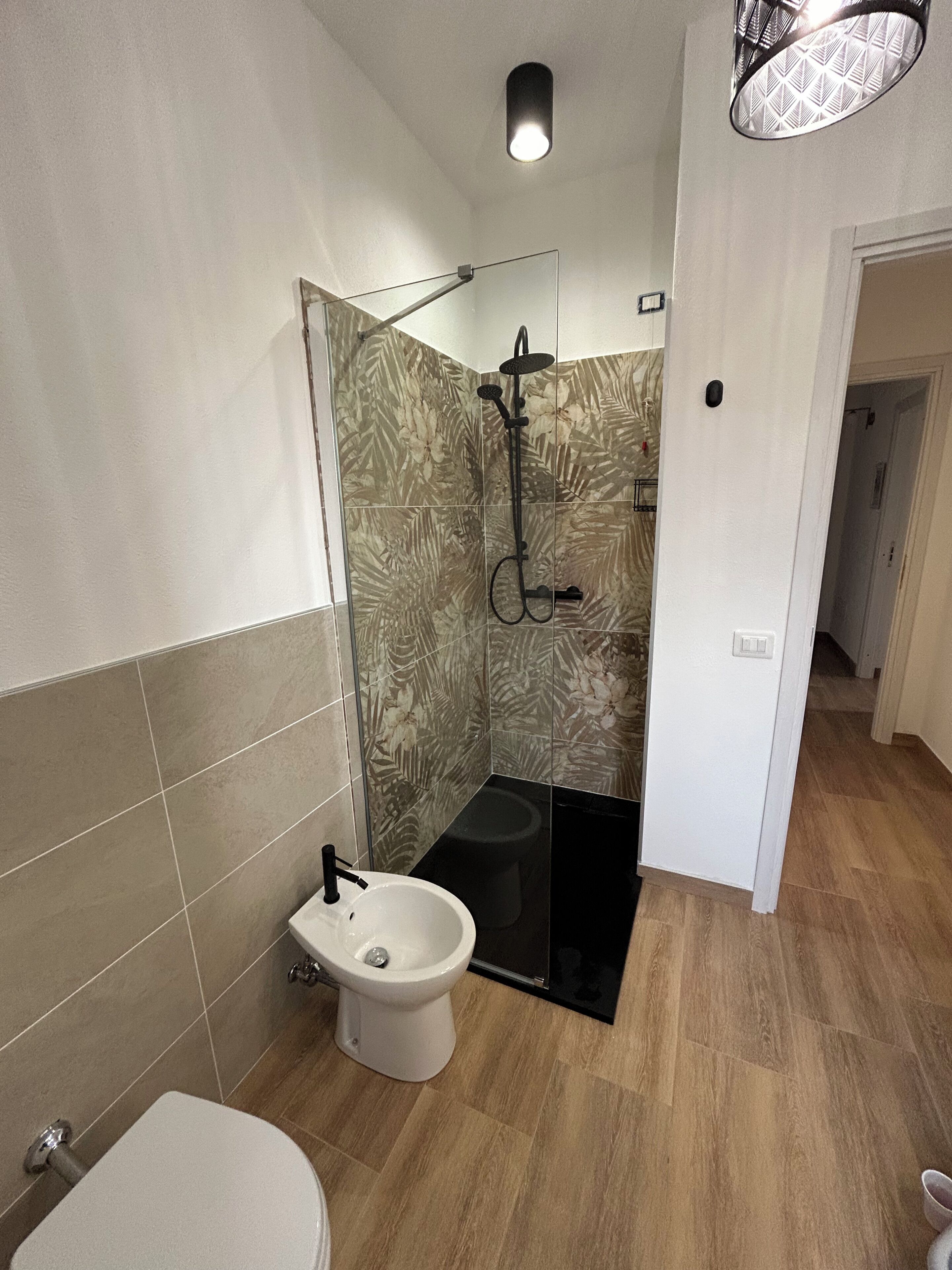 A bathroom with a toilet, bidet, and shower area.