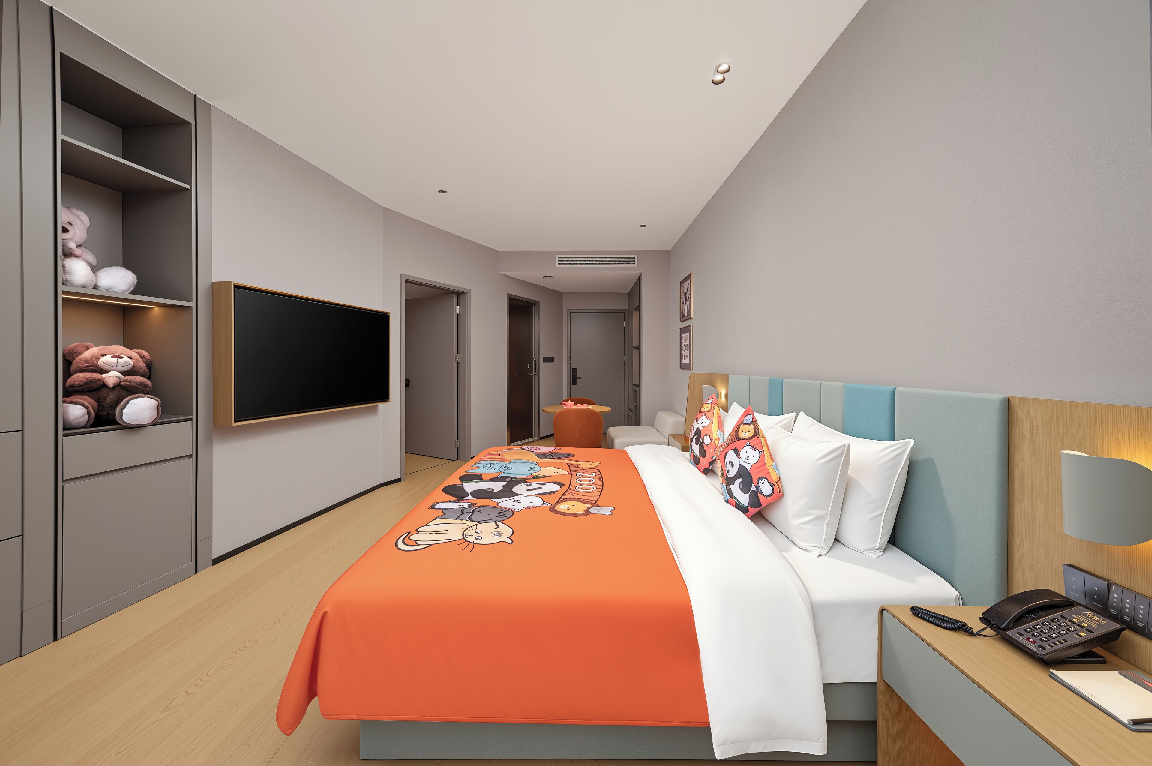 Una habitación de hotel moderna con una cama grande, un televisor fijado a la pared y un escritorio con teléfono.