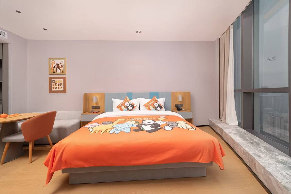 A modern hotel room with a large bed, a desk, and a chair.