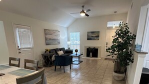 A spacious living area with a dining table, chairs, a sofa, and a fireplace. - Prime NW Austin TX near Domain, Apple, Oracle, high tech corridor upgraded home! (Austin)