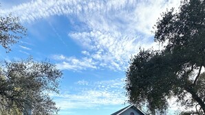 A two-story house with a garage, a brick exterior, and a large tree to the left. - Prime NW Austin TX near Domain, Apple, Oracle, high tech corridor upgraded home! (Austin)