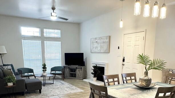 A spacious living room with a fireplace, a dining area with a table and chairs, and a television in the background. - Prime NW Austin TX near Domain, Apple, Oracle, high tech corridor upgraded home! (Austin)