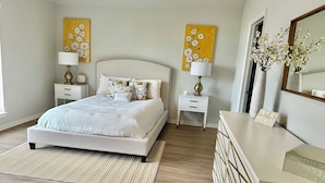 A bedroom with a bed, nightstands, a dresser, and two wall-mounted lamps. - Prime NW Austin TX near Domain, Apple, Oracle, high tech corridor upgraded home! (Austin)