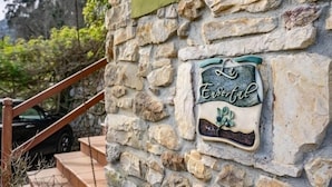 A stone wall with a sign that reads 'La Essential.'