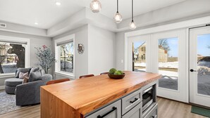 A modern kitchen with a wooden island, built-in appliances, and large windows. - Luxury Condo w/ Beach Access | Dragestil 717-1 (Duluth)
