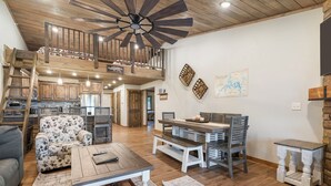 A spacious living area with a loft bedroom, wooden flooring, a dining set, and a large ceiling fan. - Large Lake Penthouse Condo, 3 bdrm, sleeps 14- Resort Amenities Galore, Ticket & Golf Deals (Branson)