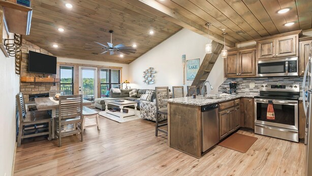 A spacious kitchen with wooden cabinets, a granite countertop, and stainless steel appliances. - Large Lake Penthouse Condo, 3 bdrm, sleeps 14- Resort Amenities Galore, Ticket & Golf Deals (Branson)