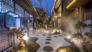 A traditional Japanese garden with a stone path, bonsai trees, and a misty atmosphere. - Yun Guan Shunde Renjia Resort Hotel (Xishuangbanna Dai)