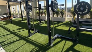 A gym with a squat rack, barbell, and weight plates.