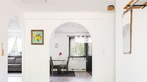 A modern interior with a dining area, white walls, and a wooden floor. - Skärvudde Villan by Interhome (Kalvsvik)