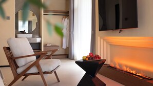 A modern living room with a flat-screen TV, a fireplace, and a wooden chair. - Bandu Oxygen Supply Homestay (Deqin)