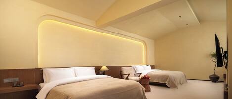 A modern hotel room with two beds, a bedside table, a lamp, and a potted plant.