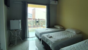 Ein Hotelzimmer mit zwei Betten, einem Fernseher und einem Balkon mit Aussicht.