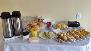 Ein reichhaltiges Buffet mit verschiedenen Speisen, darunter Brot, Gebäck und Soßen.