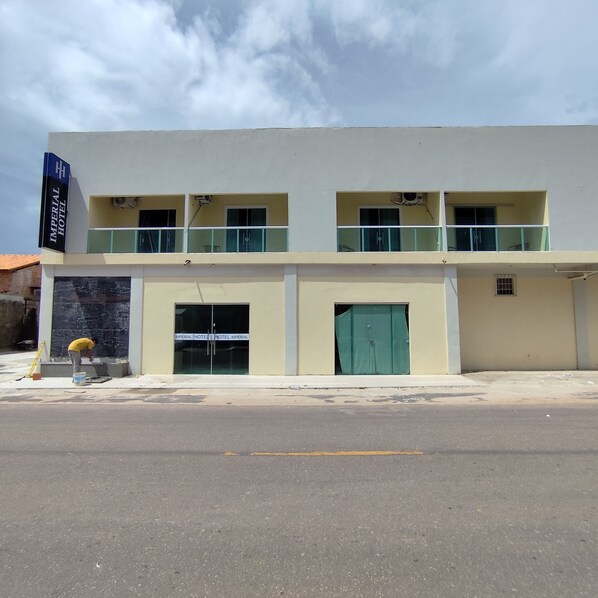 A two-story building with a sign reading "IMPERIAL HOTEL". There are two balconies on the upper floor, and a green door on the lower floor. - Imperial Hotel Barcarena sede (Barcarena)