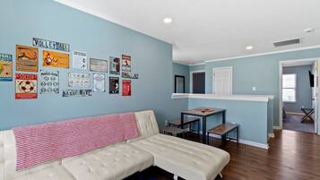 A living room with a sofa, a coffee table, and a wall decorated with sports memorabilia.
