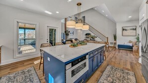 Una cocina amplia con una isla grande, piso de madera y vistas al exterior.