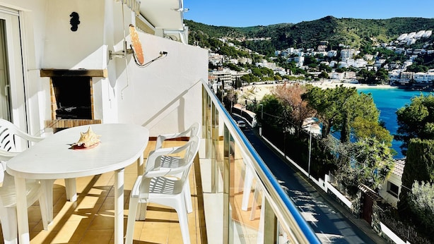 A balcony with a table and chairs, overlooking a coastal town with buildings and a beach. - 2210 - MIRADOR II 55 WONDERFUL SEA VIEW, IDEAL SITUATION FOR HIKING, 150m. FROM THE BEACH OR FROM THE ROCKS. (Roses)