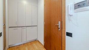 Ein Zimmer mit Holztür, fest installiertem, weißem Telefon und einem weißen Kleiderschrank.