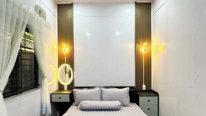 Een slaapkamer met een bed, nachtkastjes, een spiegel en wandlampen.