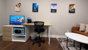 Ein modernes Homeoffice mit Schreibtisch, Stuhl und Fernseher, der einen Disney-Sender zeigt.