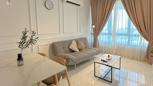 Una sala de estar moderna con techo blanco, ventilador de techo, sofá, mesa de centro y mesa de comedor con sillas.