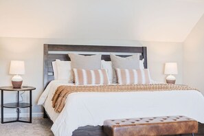 A neatly arranged bedroom with a bed, two bedside tables, and a bench.