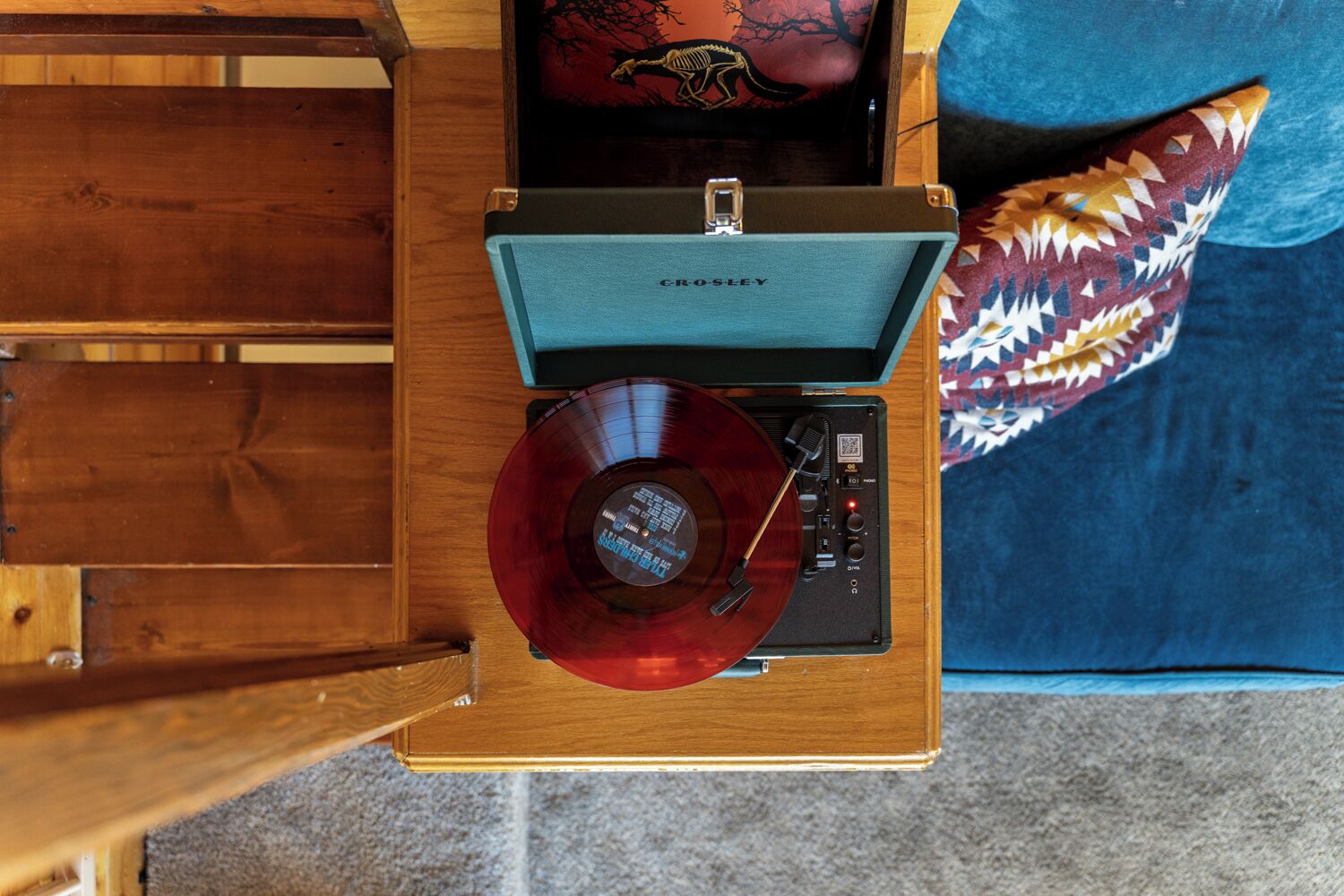Une platine vinyle ancienne, avec un disque posé dessus, placée sur une table en bois.
